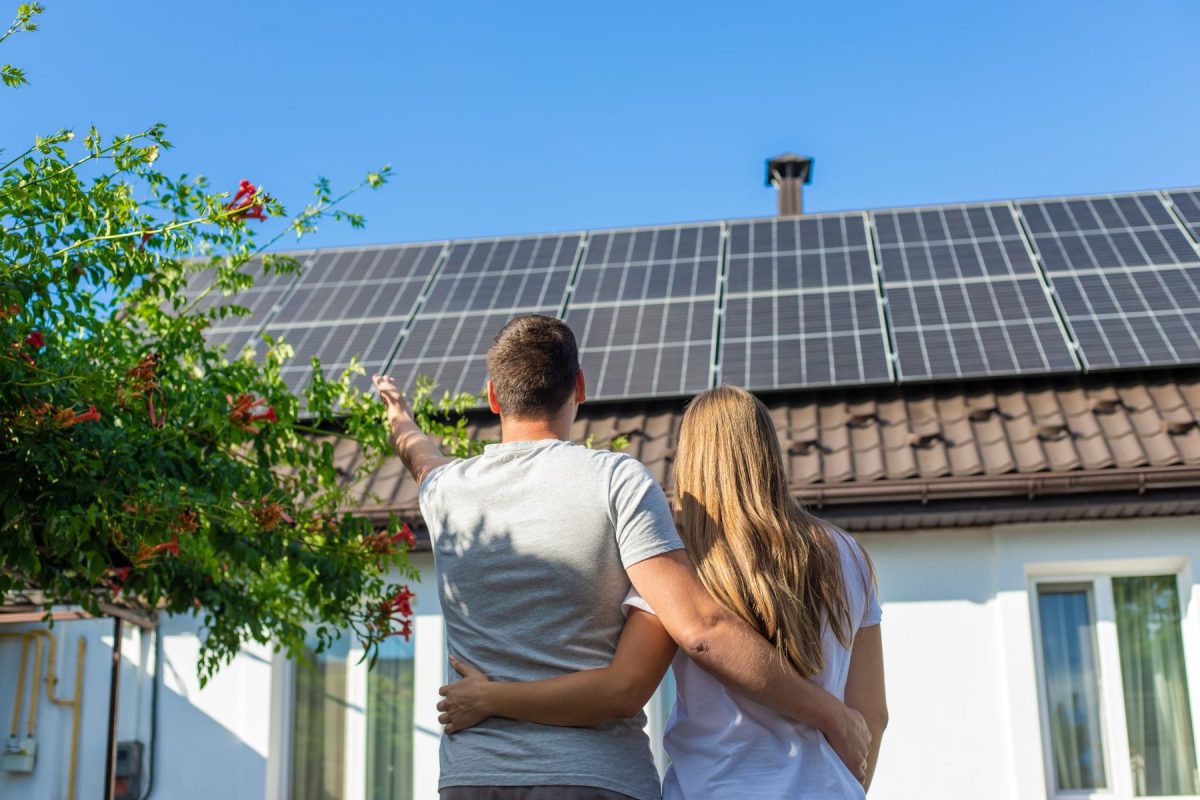 Couple looking at solar panels on house